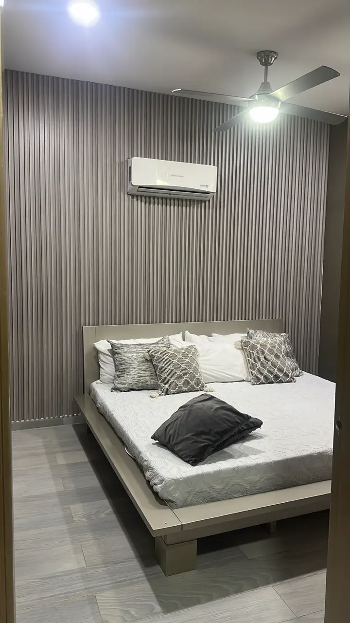 Habitación con cama doble, aire acondicionado y ventilador